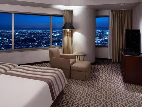 a hotel room with a bed and a television at Yokohama Royal Park Hotel in Yokohama