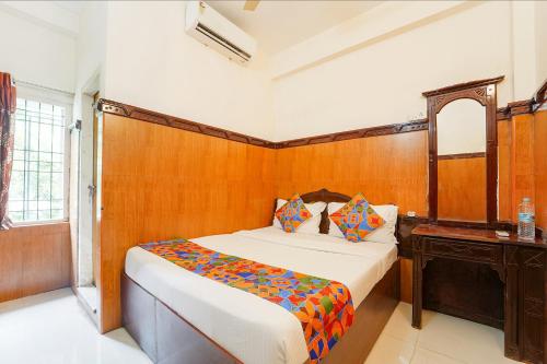 une chambre avec un lit et un mur en bois dans l'établissement Ascot Hotel, à Cochin