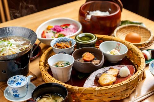 a table with a basket of food and bowls of food at Yufuin Souan Kosumosu in Yufuin