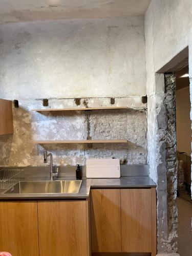 a kitchen with a sink and a stone wall at nook Inn in Seoul