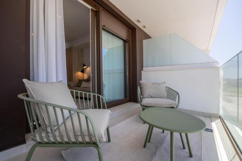 ein Zimmer mit zwei Stühlen und einem Tisch und einem Fenster in der Unterkunft Calma & Beach Estepona Retreat in Estepona