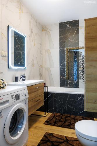 a bathroom with a washing machine and a shower at Apartament Jaśmin in Stargard