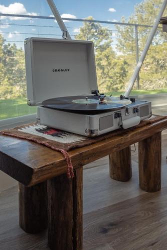 a projector on a wooden table with a window at Freya Geo Dome Suite At El Mistico Ranch in Nogal
