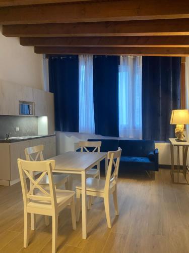 a dining room table with chairs and a blue couch at Hotel International in Tarvisio