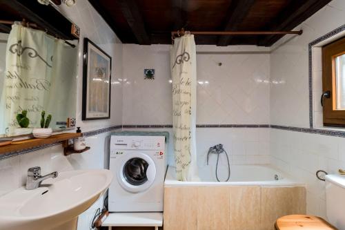 ein Badezimmer mit Waschmaschine und Waschbecken in der Unterkunft Casa De Campo Las Rozas in Puente Viesgo