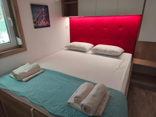 a bedroom with a bed with two towels on it at Sunrise Wellbeing mobile home for mindful, vegetarian, active rest, just 35 meters from the sea in Grebaštica