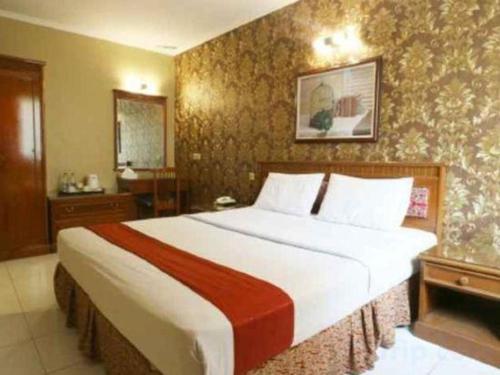 a bedroom with a large bed in a room at Hotel Permata Bandara in Jakarta