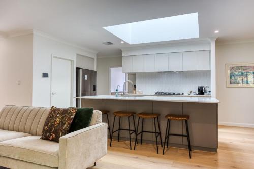 a living room with a couch and a kitchen at Peppermint Breeze in Vasse