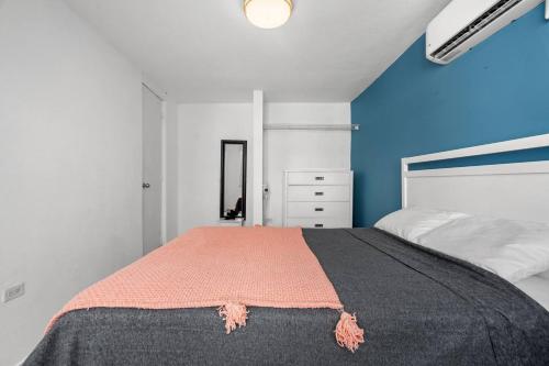 a bedroom with a bed and a blue wall at Nice Pool Near The Beach Free Local Coffee in San Juan