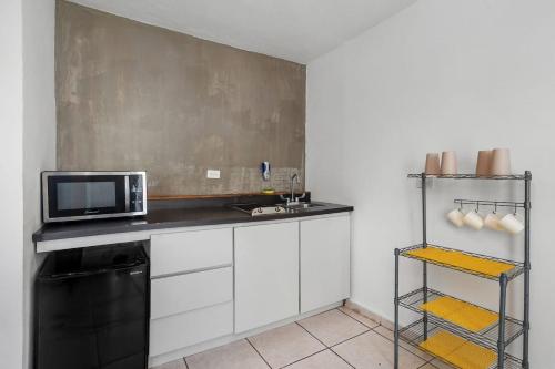 a kitchen with a microwave and a black counter top at Nice Pool Near The Beach Free Local Coffee in San Juan