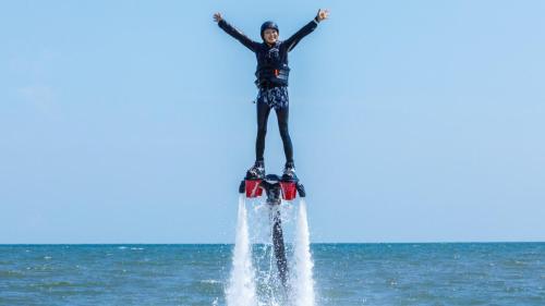 a person on a water board in the ocean at そらすな Beach Side Resort Hotel in Yukuhashi