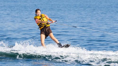 a woman is water skiing on the water at そらすな Beach Side Resort Hotel in Yukuhashi