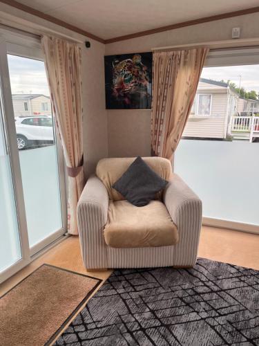 a chair with a pillow in a living room at 2 Bedroom Mini Lodge near the beach in Walton-on-the-Naze