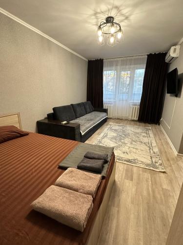 a living room with a bed and a couch at Академика Сатпаева 36 in Pavlodar