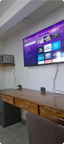 un bureau en bois avec un grand écran sur un mur dans l'établissement Habitación Ejecutiva Xico, Cedral SLP, à Cedral