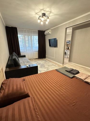 a hotel room with a large bed and a couch at Академика Сатпаева 36 in Pavlodar