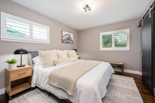 a bedroom with a large bed and two windows at Mid-mod Marvel Central Game Rmwet Bar Patio in Arvada