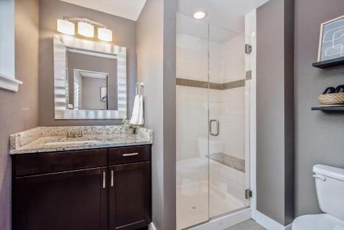 a bathroom with a shower and a sink and a toilet at Mid-mod Marvel Central Game Rmwet Bar Patio in Arvada