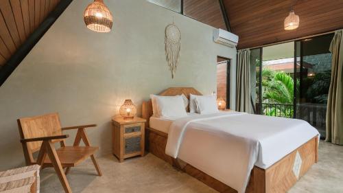 a bedroom with a large bed and a window at Kalino Villa by Betterplace in Canggu