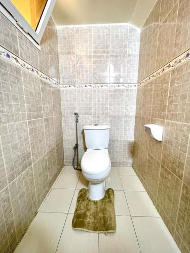 a bathroom with a toilet in a tiled room at Appartement Duplex in Dakar