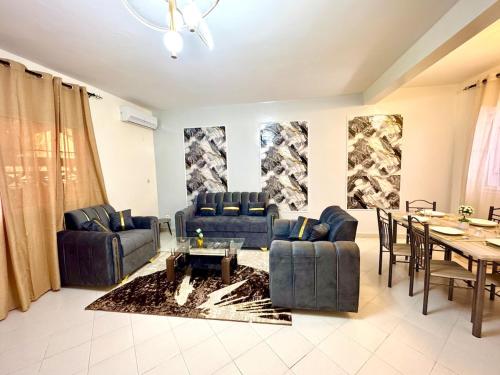 a living room with blue couches and a dining table at Appartement Duplex in Dakar