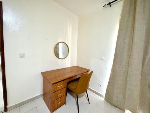 a desk in a room with a chair and a mirror at Appartement Duplex in Dakar