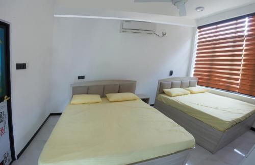 a bedroom with two beds and a window at Dream House in Kirinda