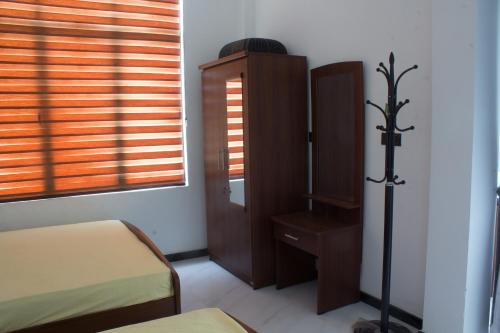 a bedroom with a bed and a cabinet and a window at Dream House in Kirinda
