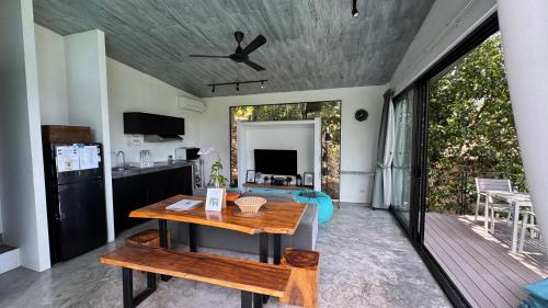 a kitchen and dining room with a table and a patio at Pahili Pool Villas Koh Tao - SHA Plus in Koh Tao