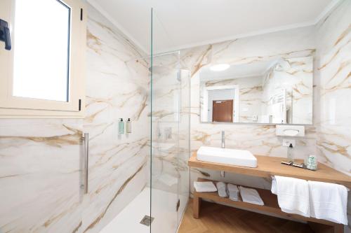 a bathroom with a sink and a glass shower at Hotel Bristol in Lido di Jesolo