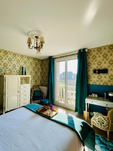 a bedroom with a large bed and a window at La Maison au toit vert in Espalion
