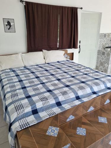 a bed with a blue and white checkered blanket at Villas La Vista in Tuxpan de Rodríguez Cano