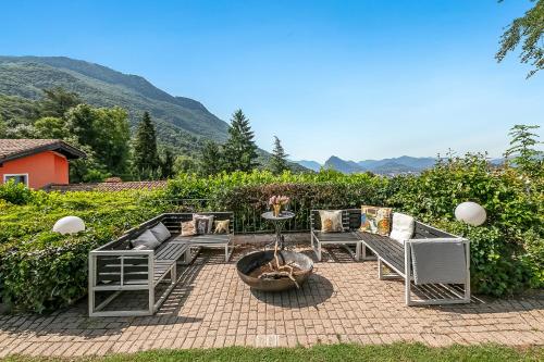 ルガノにあるVilla Tre Piniのパティオ(椅子、テーブル、ファイヤーピット付)