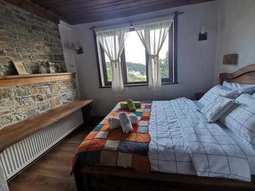 a bedroom with a bed with a colorful blanket at Къщата на музиканта in Leshten