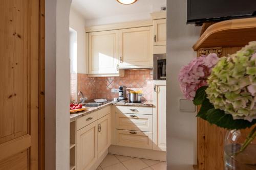 a kitchen with white cabinets and a sink at Boutique Appartments Gerlosperle in Gerlos