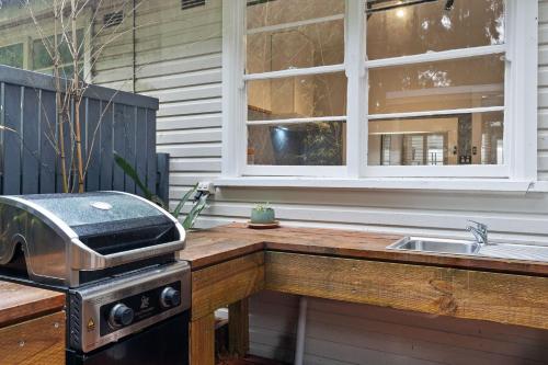 - une cuisine avec un comptoir, une cuisinière et un évier dans l'établissement Mountain Escape in Katoomba, à Katoomba