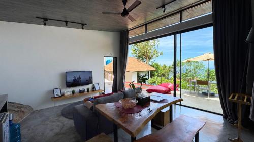 a living room with a couch and a table at Pahili Pool Villas Koh Tao - SHA Plus in Koh Tao