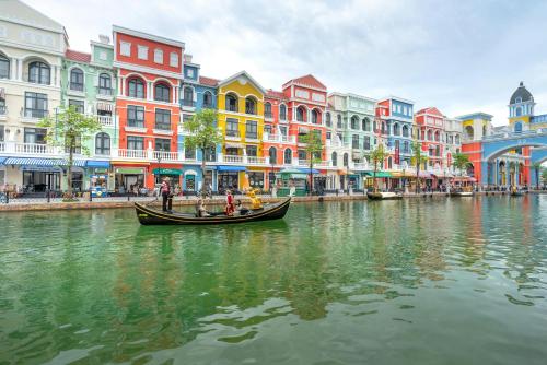 Un grupo de personas en una góndola en un río con edificios. en Lalisa Hotel Grand World Phu Quoc, en Phu Quoc