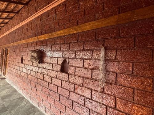 a red brick wall with two holes in it at Ranjanghar in Gimvi