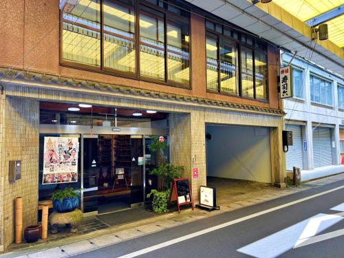 a large brick building with windows on a street at 寿司六旅館 in Miyoshi