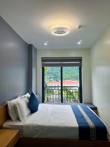 a bedroom with a bed with a large window at Sky Hotel & Homestay Ha Giang in Ha Giang