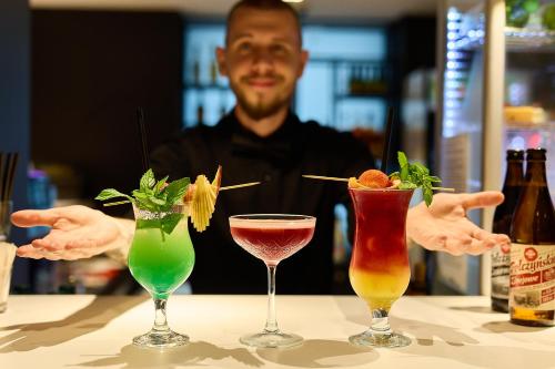 a man sitting at a table with four cocktails at Barbarka Vita w Świnoujściu in Świnoujście