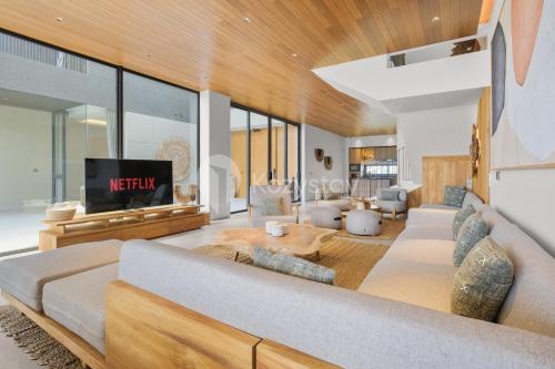 un salon avec un canapé et une télévision dans l'établissement Dago Escape Villa by Kozystay - Bandung, à Ciburial