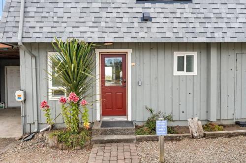 a house with a red door with a sign in front at Tide Pool Town Home, Entire House, Amazing Views! in Moclips