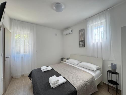 a bedroom with a bed with two towels on it at Flowers Apartments Pula, city center 2 in Pula