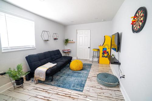 a living room with a black couch and a tv at Chic & Stylish Central location in Tampa
