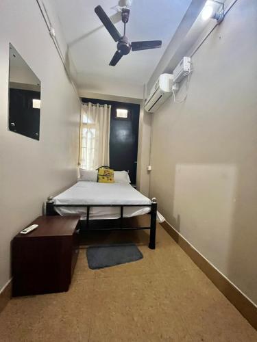a room with a bed and a ceiling fan at Aura House Homestay in Guwahati