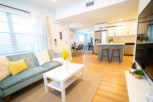 a living room and kitchen with a couch and a table at Chic & Stylish Central location in Tampa