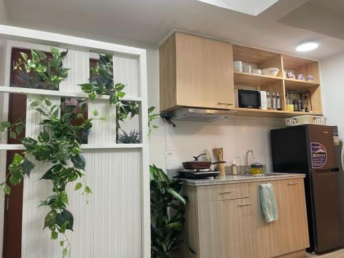 a kitchen with a refrigerator and some plants at Mesavirre Bacolod - High Floor, Beautifully Furnished 1BDM with Balcony in Bantud Hacienda