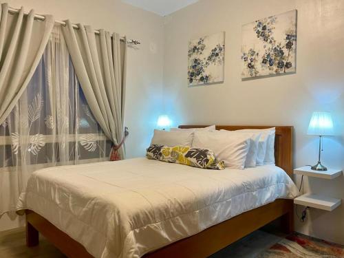 a bedroom with a bed and a window at Mesavirre Bacolod - High Floor, Beautifully Furnished 1BDM with Balcony in Bantud Hacienda